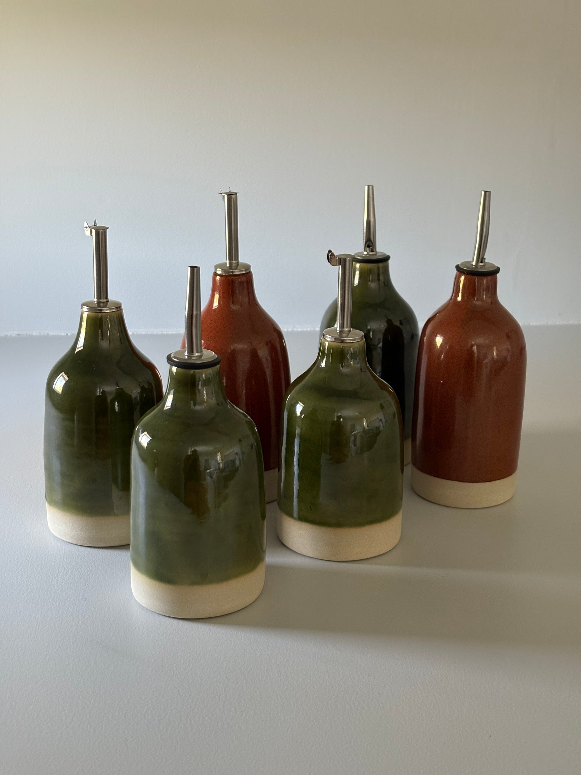 Drejade oljeflaskor i stengods med grön och roströd glasyr, från MP Ceramics