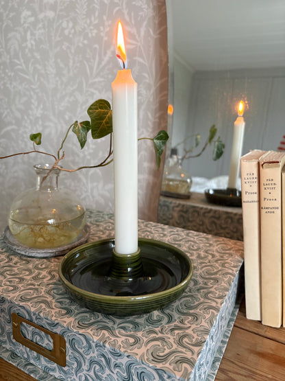 Grön drejad ljusstake i stengods med tänt kronljus
